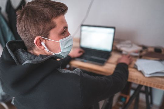 Active teen Boy in face mask with laptop homework during coronavirus quarantine.