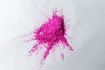 paints for the Holi festival, pink pigmented friable paints lie on a white surface