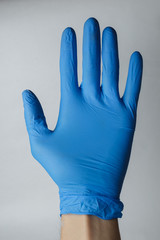 Fototapeta premium hand in a medical glove, gestures. Suitable for demonstrating something on the topic of medicine or chemistry