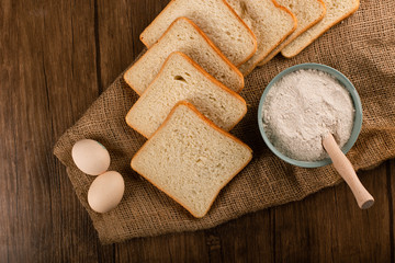 Fototapeta na wymiar Slices of bread with bowl of flour and eggs