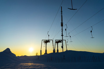 Hooks are hanging on a lift cable in a ski resort in winter