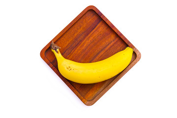 Yellow ripe bananas on a wooden board, isolated from a white background and copy space