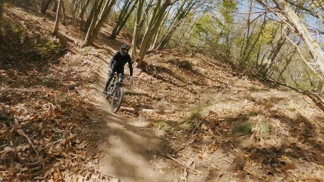 Extreme speed MTB bike riding on trails with berms and rocks on sunny day. View from first person perspective POV. 