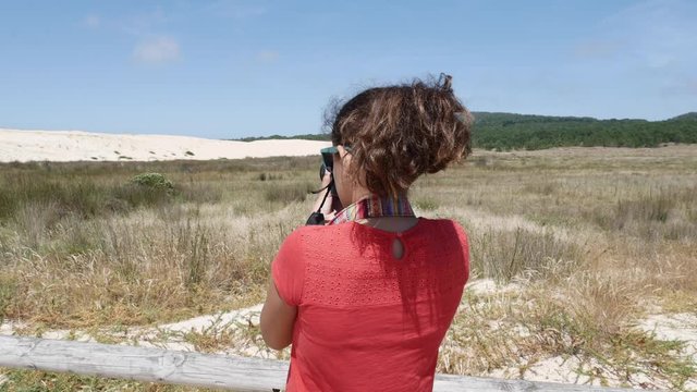 teenage girl taking photos on a popular touristic site, sand dunes of Corrubedo, A Coruña