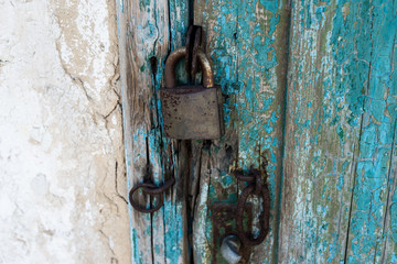 Padlock on the background of a closed old wooden door. Grunge background