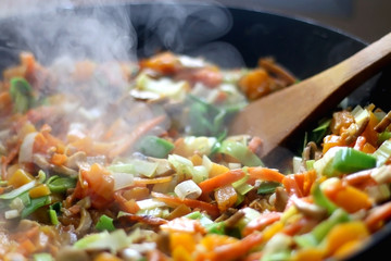 Stir- fry vegetables and portobello mushrooms in a wok. Selective focus.