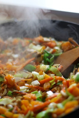 Stir- fry vegetables and portobello mushrooms in a wok. Selective focus.