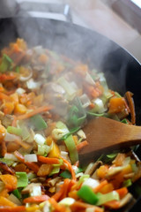 Stir- fry vegetables and portobello mushrooms in a wok. Selective focus.
