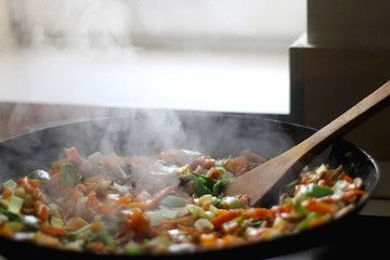Stir- fry vegetables and portobello mushrooms in a wok. Selective focus.