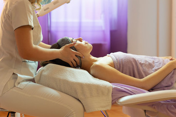 Beautiful woman in spa salon getting face treatment