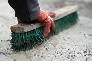 manual worker cleans a dirty granite pavement in front of the house, spring cleaning in the yard