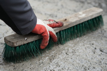 manual worker cleans a dirty granite pavement in front of the house, spring cleaning in the yard