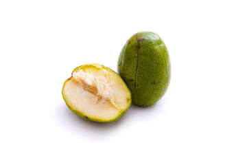 fresh green ambarella fruit that is still intact and that has been cut, isolated from a white background and copyspace, scientific name: Spondias dulcis