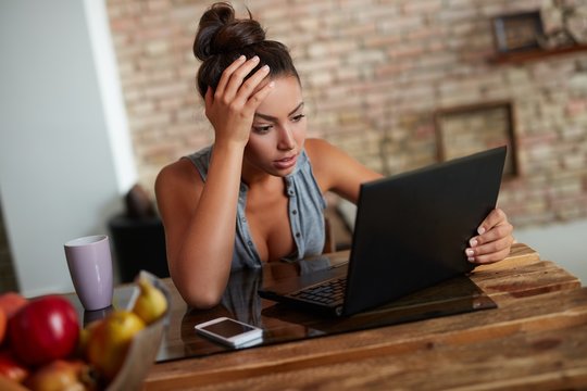 Stay at home - woman working on computer at home reading bad news online
