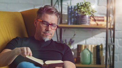 Stay at home - Older white man in glasses reading at home