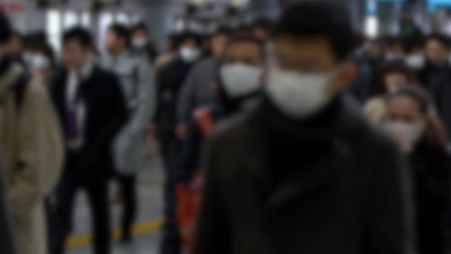 Slow motion Blurred defocused view of Japanese business men and women wear face masks. People wearing mask at metro as precautionary measures during coronavirus from Wuhan, China-Dan