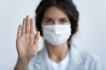 Help stop spreading globally corona virus pandemic infectious disease outbreak. On background woman in mask focus on stretched hand as symbol of keep distance avoid communication, healthcare concept - obrazy, fototapety, plakaty