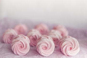 Obraz na płótnie Canvas Homemade pink marshmallows on pastel pink background. Creative concept Marshmallow, Meringue. Homemade Sweets dessert
