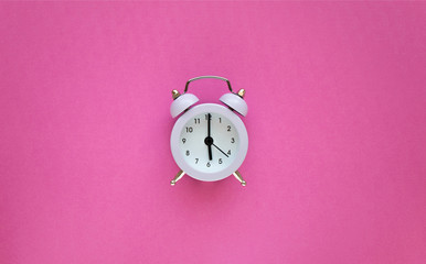 Vintage light alarm clock on pink background