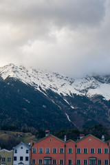 Fototapeta na wymiar Alpine mountains with snowy peaks. Old european houses. Blue sky with clouds.