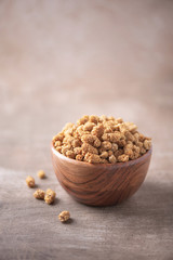 White dried mulberry in wooden bowl on wood textured background. Copy space. Superfood, vegan, vegetarian food concept. Macro of mulberry berries, selective focus. Healthy snack.