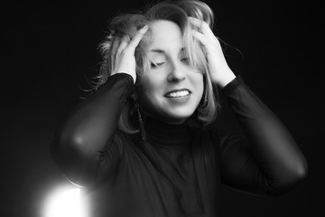 Classic black-and-white dramatic portrait of an blonde woman in Studio on black background.