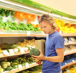 Young man buying vegetables at the market	