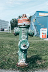Fototapeta na wymiar Old green fire hydrant in the city