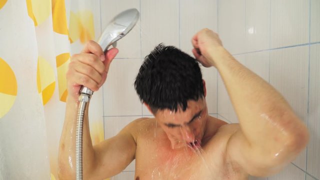 Funny Guy In The Bathroom Dancing And Singing Holding A Shower, And Watering With Water