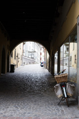 Fototapeta premium Old european street with paving stones and a bicycle