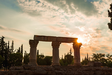 Siluette of anchient ruins of temple in Corinth, The lights of sun brights through. Greece - archaeology background