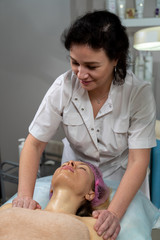 Beautician makes a procedure for a girl to improve facial skin condition