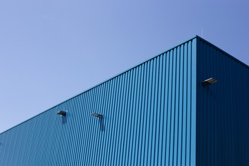 Blue metal building on sky background