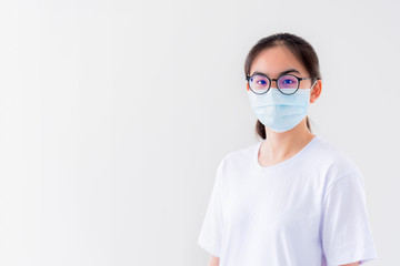 Studio portrait Asian young woman wears glasses and mask to protect against Coronavirus looking at camera, Thailand girl people on white background blank or copy space for anti virus Covid 19 concept