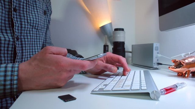 The chief news editor pushes buttons on the keyboard while sitting at the table. The concept of preparing fresh information.