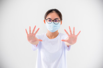 Portrait Asian young woman wears glasses and mask to protect against Coronavirus looking at camera, girl show hands stop coronavirus outbreak isolated on white background stop virus Covid 19 concept