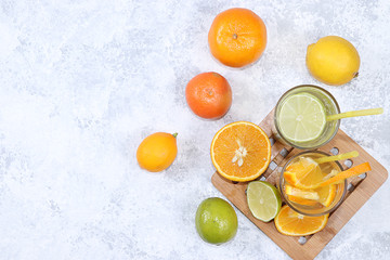 Citrus cider, juice, drink and ingredients on a concrete table. The concept of detox diet and weight loss, natural nutrition, increasing the body's immunity against viruses and colds
