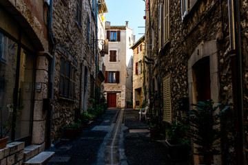Fototapeta na wymiar A narrow small street in the old medieval center of a French town in the morning after rain (Vence, France)