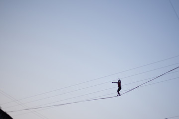 Man balancing on a rope against the sky