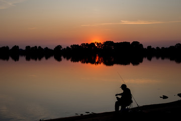 Fototapeta na wymiar Fisherman at dawn fishing on a fishing rod