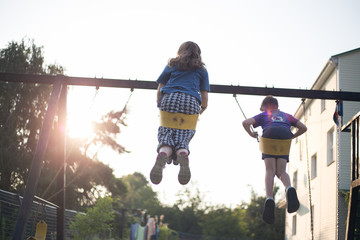 Kids in the backyard swing at sunset