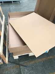 Empty cardboard packaging on a wooden pallet in a warehouse