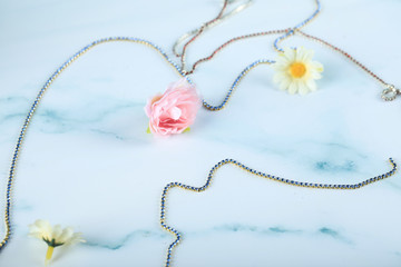 Metallic chain and flowers on a blue background