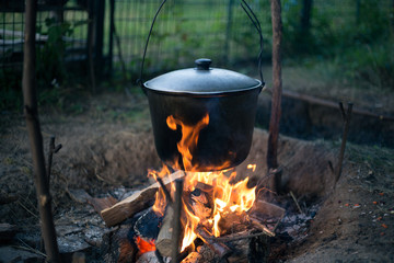 Cauldron with soup on a campfire in a hike