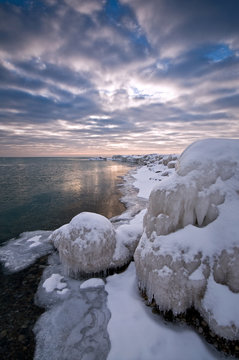 A Dramatic Winter Sunrise Over Shoreline Ice Formations On Lake Michigan Shoreline.