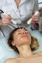 cosmetic procedure to improve the condition of the skin of the face with microcurrents for a girl.
