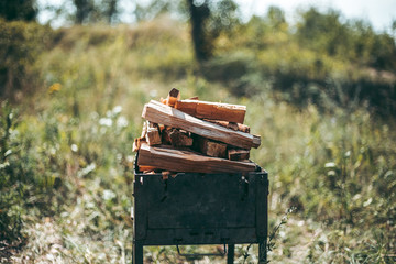 Firewood is burning on the grill on the street.