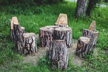 Obraz premium Outdor park in the forest with wood table and chairs made out of wood sculpted by hand, beautiful relaxation space