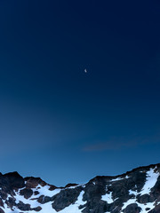 Noche de luna con vista de montaña nevada en la cumbres