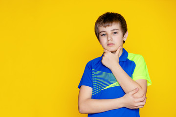 Baby girl teenager 11-12 years old in a sports uniform on a yellow background.